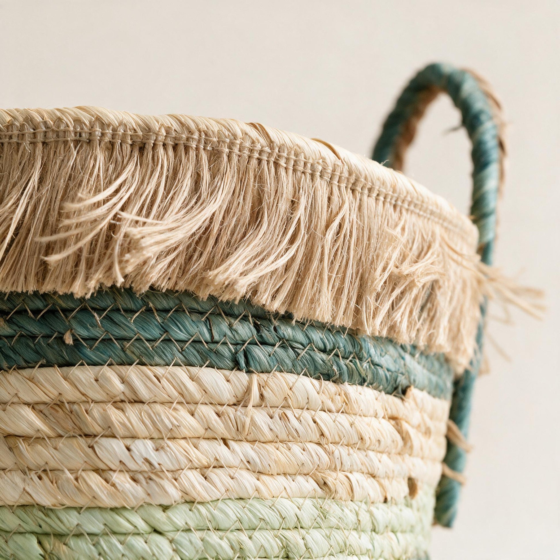 Close-up of the frayed raffia fringe collar, natural straw rim and teal, cream and mint-sage colour bands — Lumara Home