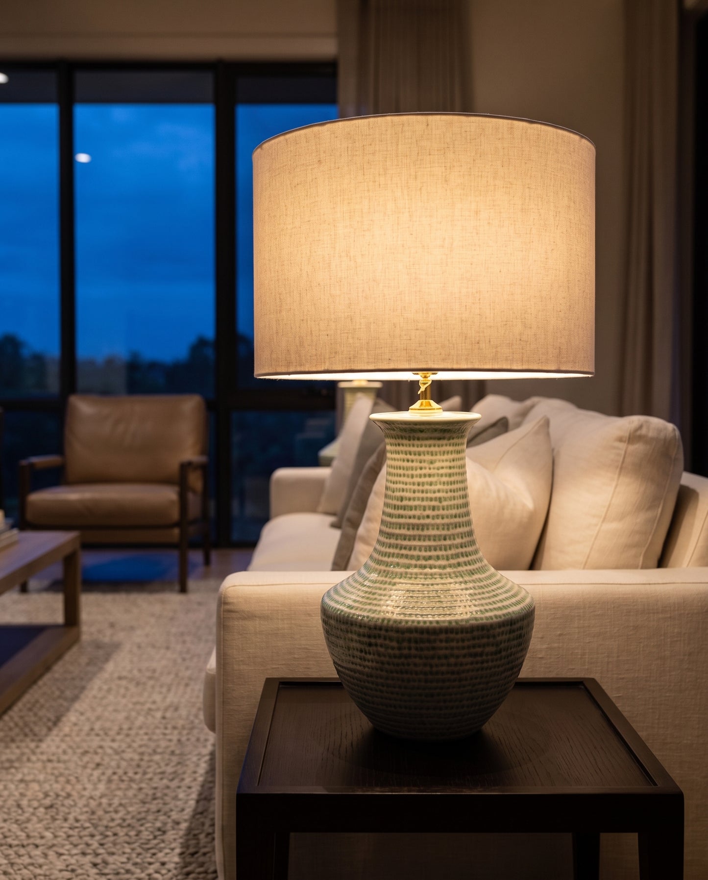 Lumara Chike Table Lamp lit at dusk in a refined living room — Lumara Home