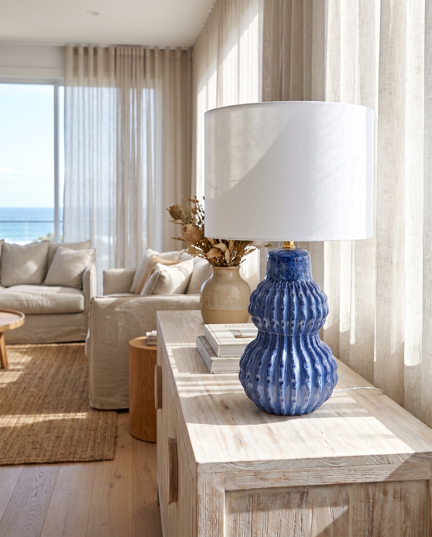Malabar Table Lamp ocean blue on a coastal console in morning light — Lumara Home