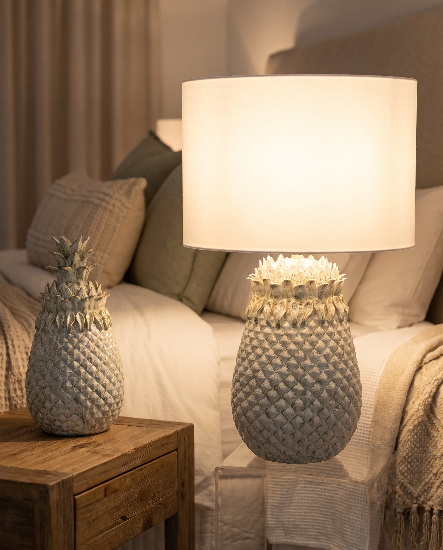 Weathered Pineapple Table Lamp lit in a guest bedroom — Lumara Home