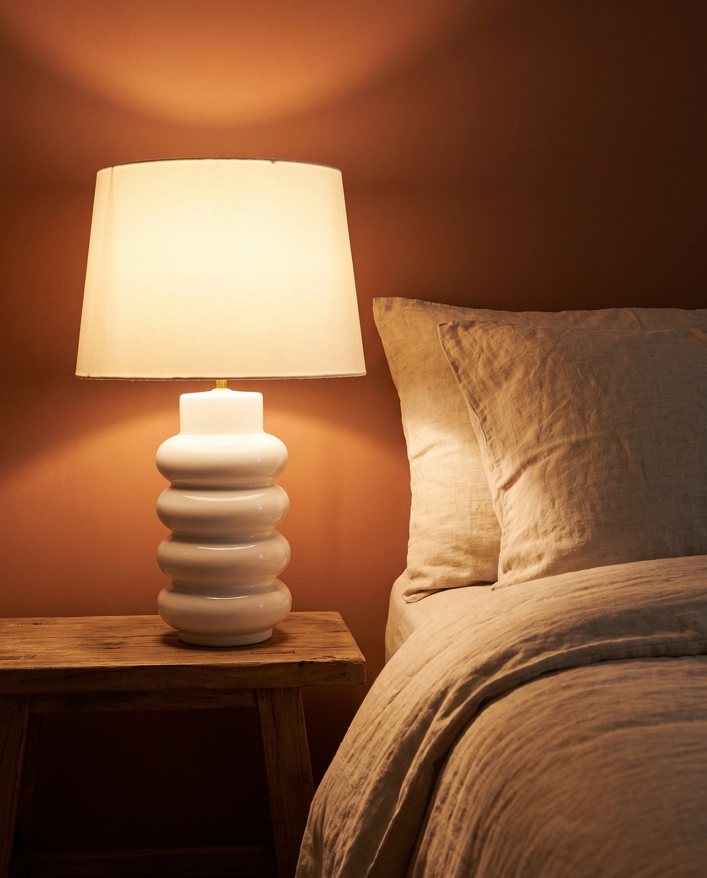 Lumara White Foam Table Lamp lit at dusk on a bedside table — Lumara Home