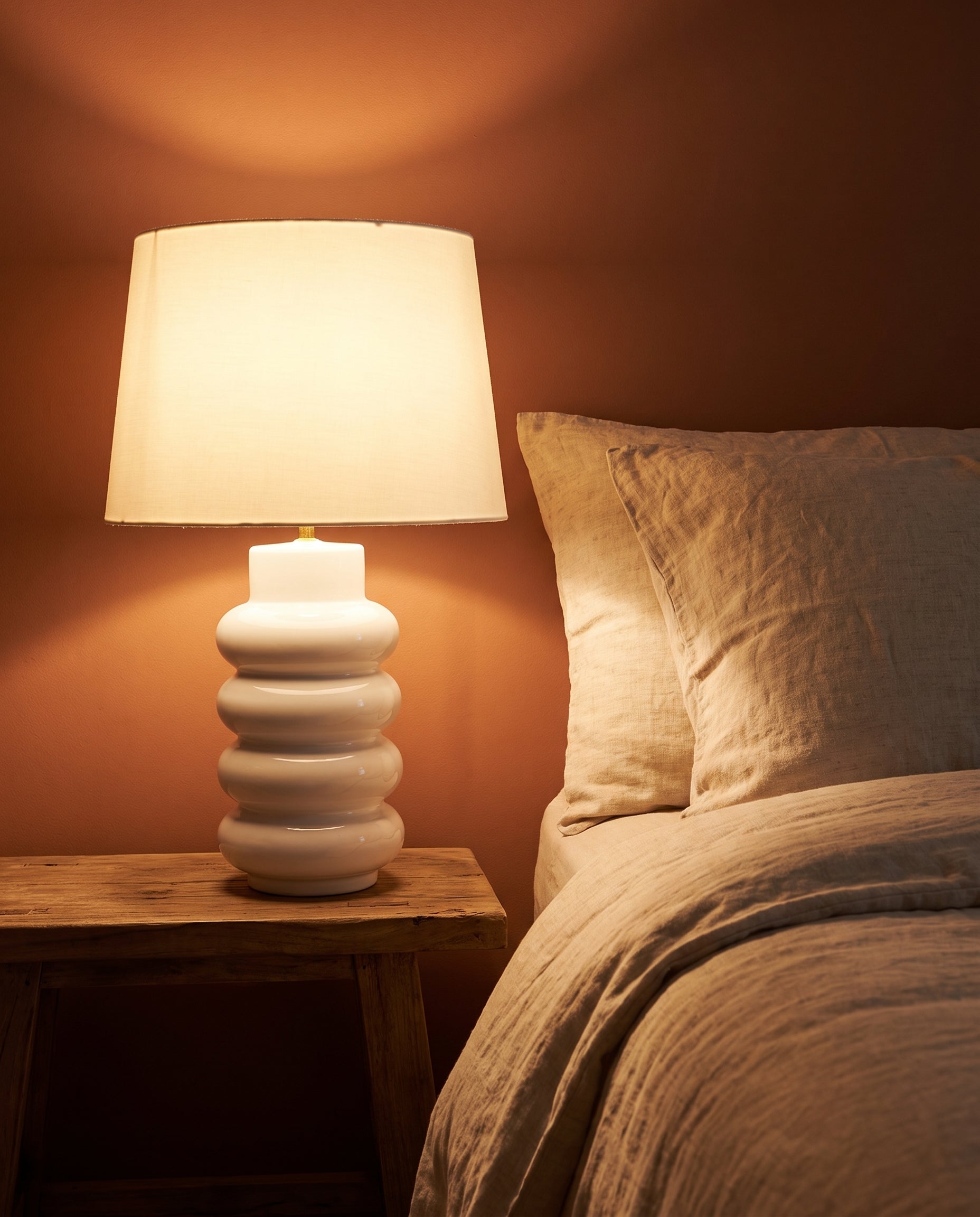 Lumara White Foam Table Lamp lit at dusk on a bedside table — Lumara Home